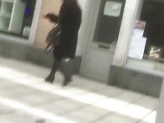 Reife Frau in schwarzen Stiefeln und der coat